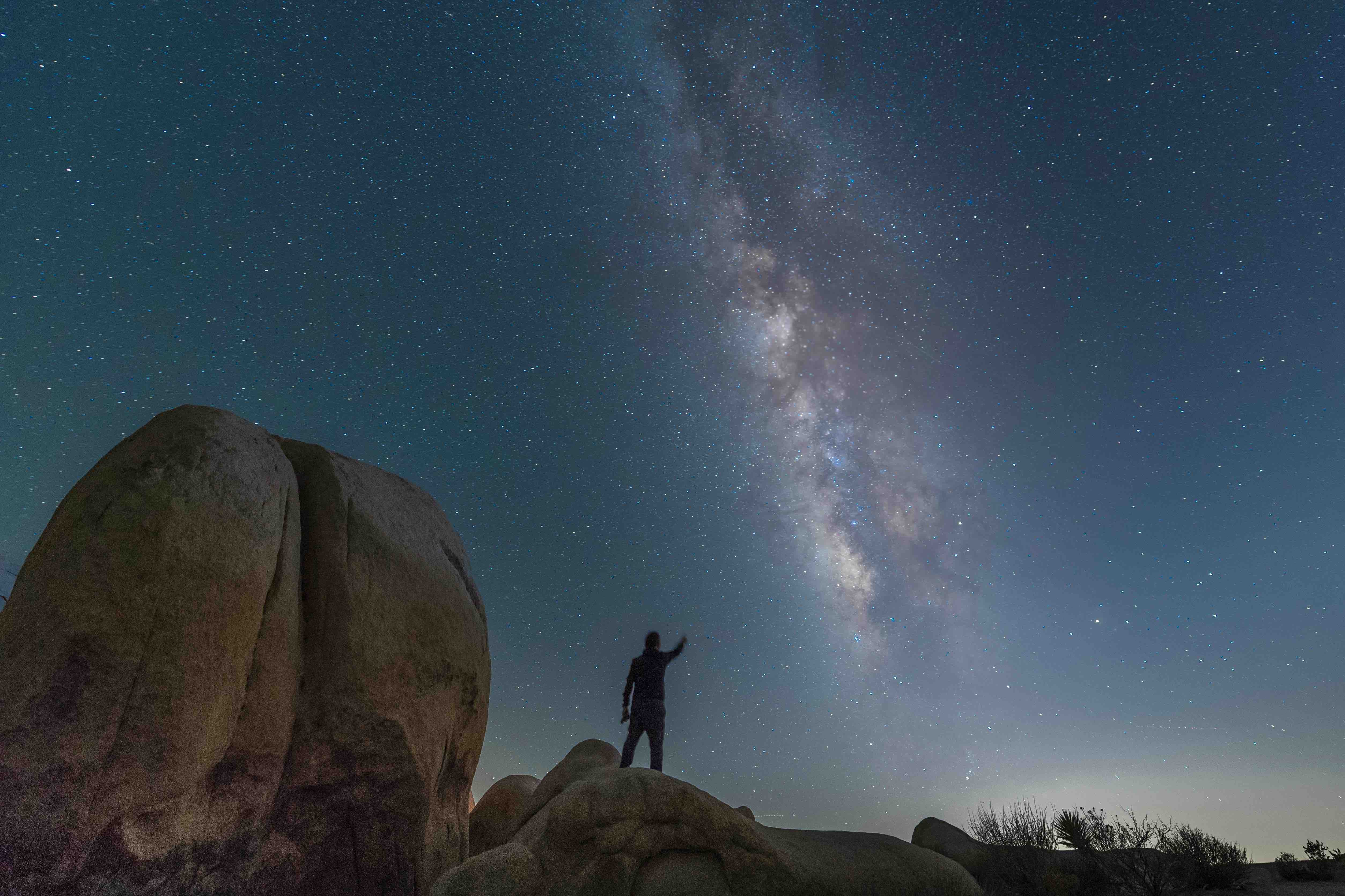 Man standing and stargazing at a night sky